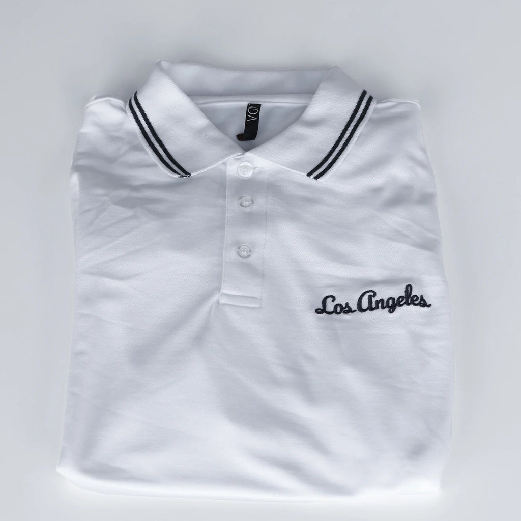 White polo shirt with 'Los Angeles' embroidery on a light gray background