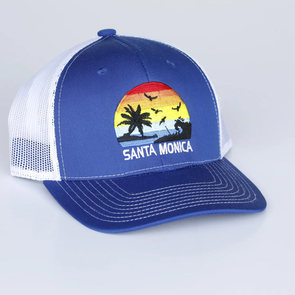 Blue and white cap with a beach graphic and 'Santa Monica' text on a light gray background