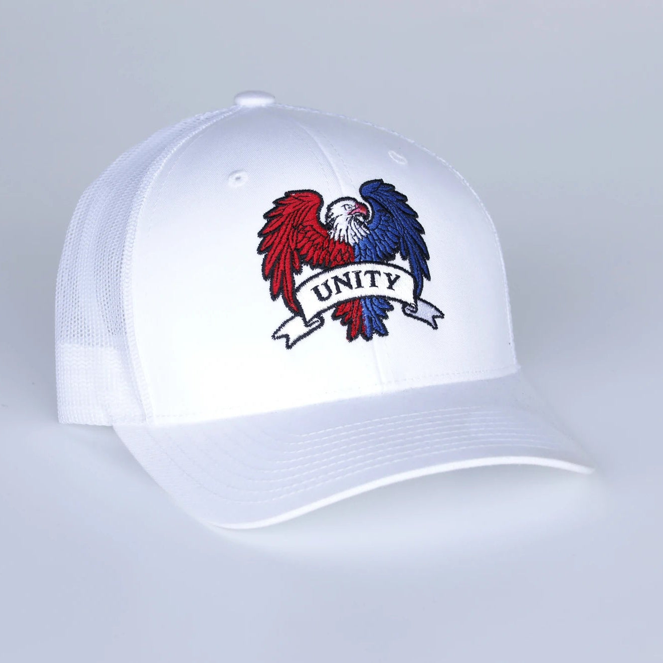 White cap with a colorful emblem and 'UNITY' text on a light gray background